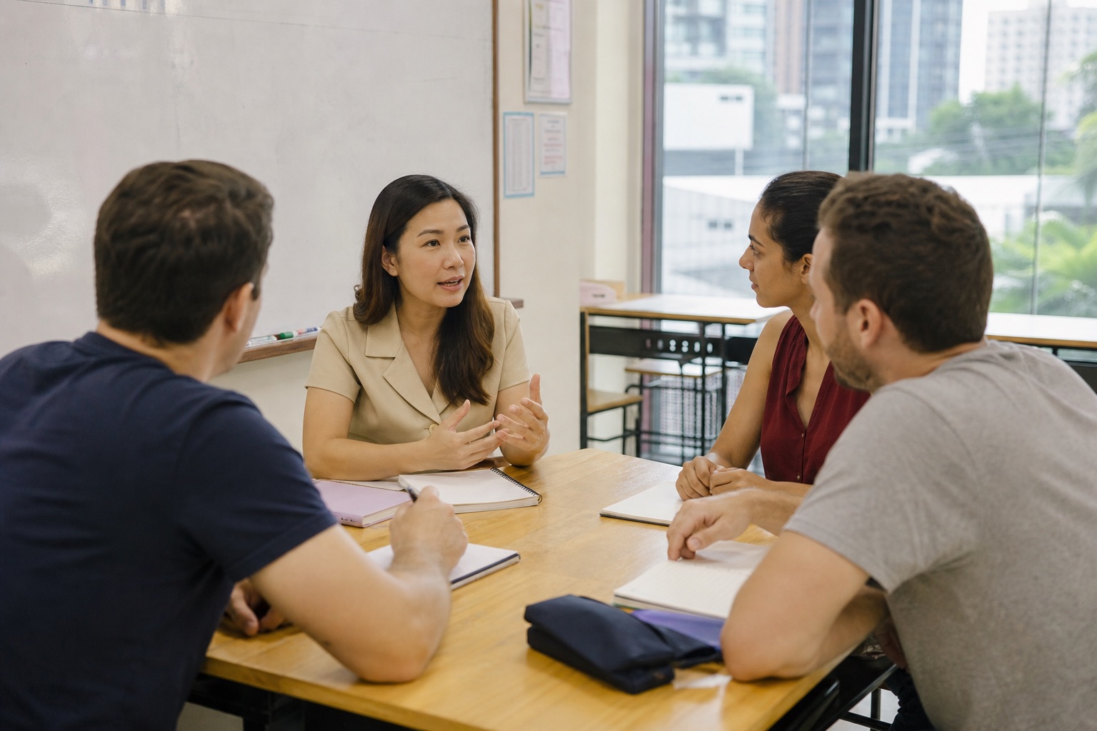 Adult students speaking with a teacher in a Bangkok language classroom